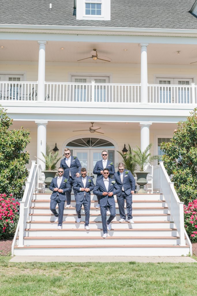 groomsmen walking down the steps at weatherly waterfront farm photography by costola photography