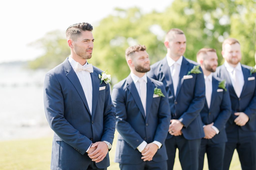groom at ceremony at weatherly waterfront farm photography by costola photography