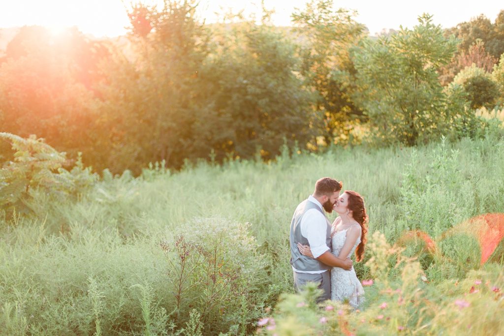 Bride and Groom kissing in field in classic Tennessee wedding by Costola Photography