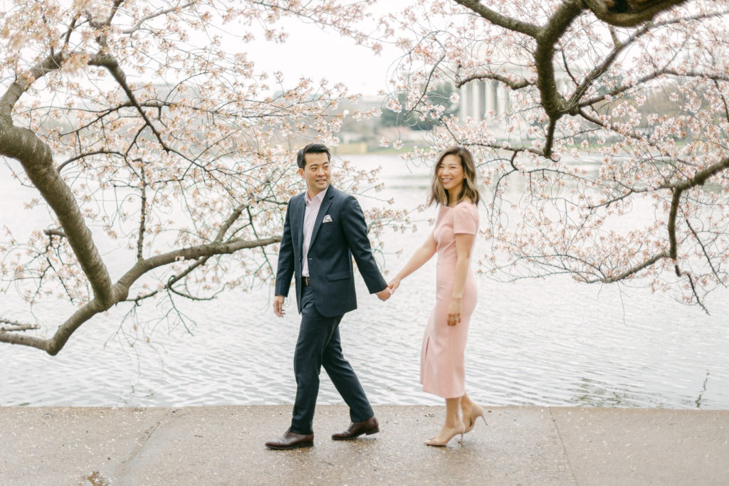 a couple posing in the cherry blossoms